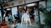 a woman is carrying another woman on her back in front of a store that says ' a ' on the front
