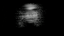 a black and white photo of a person 's face floating in the water .