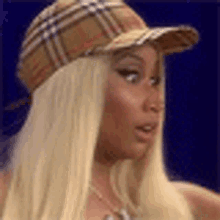 a close up of a woman wearing a plaid hat .