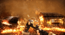 a person holding a gun in front of a fire