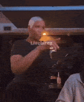 a man in a black shirt is dancing in front of a sign that says livebitez on it