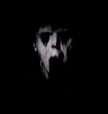 a close up of a person 's face in the dark with a black background .