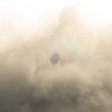 a man in a superman costume is walking through a foggy field .
