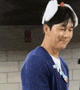 a man wearing a blue sweater and a white headband with ears