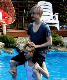 a man is carrying another man on his back in a pool