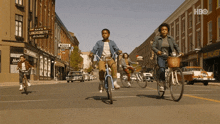a group of people riding bicycles down a street with a sign that says luncheonette on it