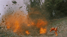 a robot is standing in front of a huge explosion
