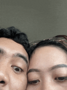 a close up of a man and a woman 's faces with glasses on