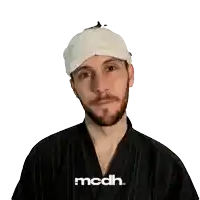 a man wearing a white hat and a black shirt with the word mcdh on the front