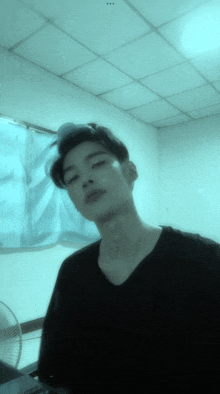 a young man in a black shirt is standing in a room