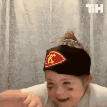 a little girl wearing a chiefs hat is making a funny face