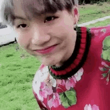 a close up of a person wearing a floral sweater and smiling .