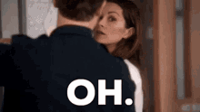a man and a woman are standing next to each other and the woman is looking at the man .