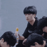 a group of young men are sitting around a table and one of them is holding a sandwich .