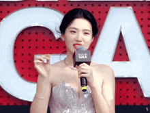 a woman holding a microphone with the word gala on it