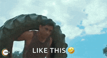 a man is carrying a tire on his back with the words `` like this '' next to him .