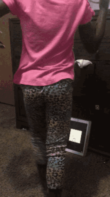 a girl in a pink shirt and leopard print pants is dancing