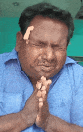 a man with a bandage on his forehead prays with his hands folded