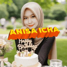 a woman in a hijab is holding a birthday cake with the name anisa icha on it