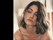 a close up of a woman 's face with short hair and a necklace .