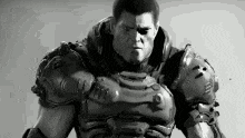a man in armor is standing in front of a white wall .