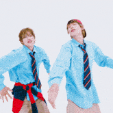 two men wearing blue shirts and ties are dancing