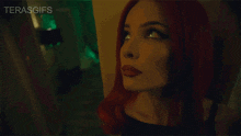 a woman with red hair looks up at the camera with the words terasgifs below her