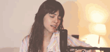 a woman is singing into a microphone while wearing pajamas