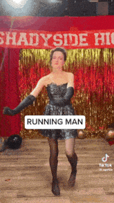 a woman in a dress and black gloves is dancing in front of a sign that says shadyside high