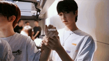 a man wearing a white shirt that says idmt on it