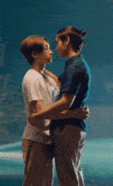 a couple of men are hugging each other in front of a blue background .