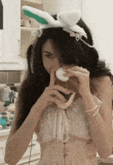 a woman wearing bunny ears and a corset is eating a watermelon