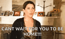 a woman is standing in front of a fireplace in a living room and says `` cant wait for you to be home ! ''
