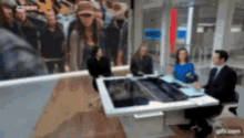 a group of people are sitting at a table in front of a screen that says cnn