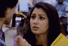 a woman with a ring on her finger looks at a man with a motorcycle in the background