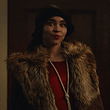 a woman wearing a fur coat and a black hat