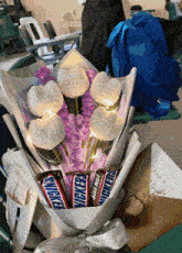 a bouquet of flowers and snickers chocolate bars