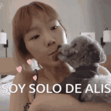a woman is holding a small dog and says " soy solo de ali "