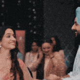 a man in a turban shakes hands with a woman in a pink saree