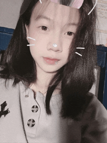 a girl with a piercing in her nose is wearing a gray shirt with buttons
