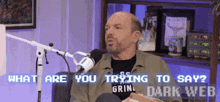 a man sitting in front of a microphone with the words " what are you trying to say " on the screen