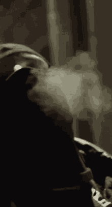 a close up of a person smoking a cigarette with smoke coming out of it