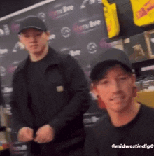two men are standing next to each other in front of a sign that says cherry live .