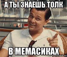 a man in a wicker chair is pointing at the camera with a meme written in russian