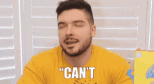 a man with a beard wearing a yellow shirt says wait