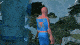 a spider-man is standing in front of a tree .