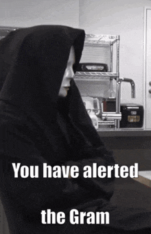 a person wearing a black hoodie with the words you have alerted the gram on it