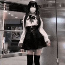 a girl wearing a mask and knee high socks is standing in a room .