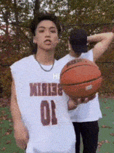 a man holding a basketball wearing a number 10 jersey