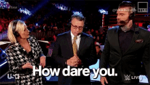 a man in a suit says how dare you while standing next to a woman and another man